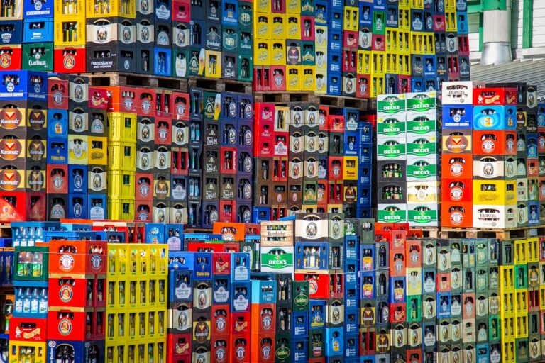 Bierkasten Maße, gestapelte Bierkästen mit unterschiedlichen Brauerei-Marken in einem Lager