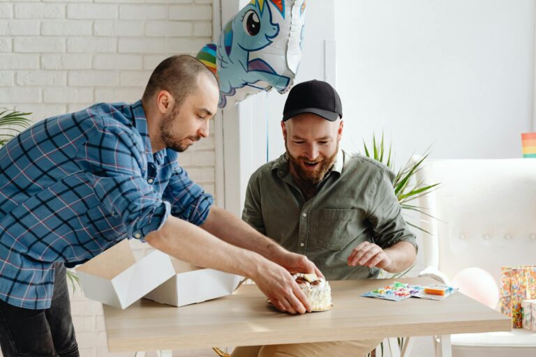 Geburtstagswünsche für Männer – zwei Männer feiern mit Torte, Ballons und Geschenken
