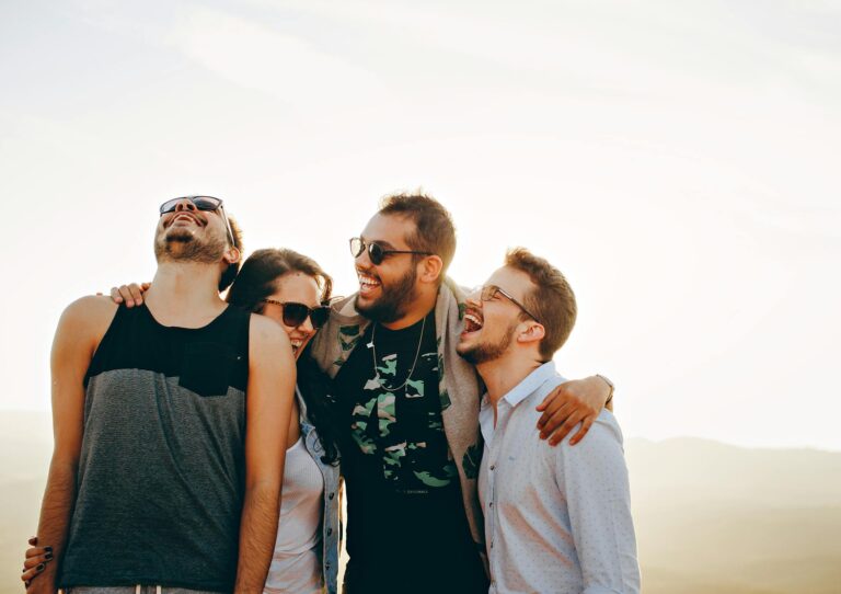 Lustige Sprüche zum Totlachen – Gruppe junger Erwachsener lacht zusammen unter der Sonne
